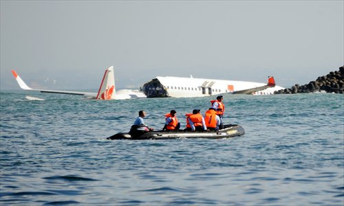 A Lion Air Boeing 737 lies submerged in the water after missing the runway during landing at Bali's international airport near Denpasar on Sunday. The Indonesian plane carrying more than 100 passengers broke in two after missing the runway on Saturday and landing in the sea, leaving dozens injured but no fatalities. Photo: AFP