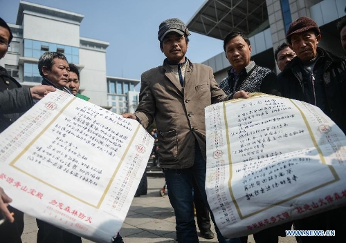 Chen Jiahe (C), a job seeker from east China's Jiangxi Province, demonstrates poems written by him at a job fair in Yiwu, east China's Zhejiang Province, Feb. 16, 2013. China has begun to see a resurgence in the number of both employers and job seekers after the week-long Spring Festival holiday. (Xinhua/Han Chuanhao)