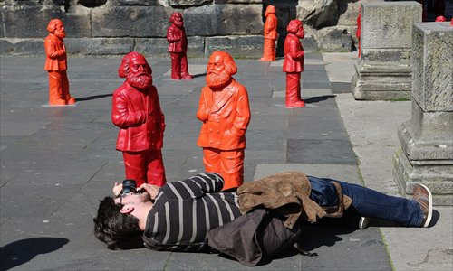 A visitor takes a photo of some of the 500, one-meter tall statues of German political thinker Karl Marx on display on Sunday in Trier, Germany. The statues, created by artist Ottmar Hoerl, are part of an exhibition at the Museum Simeonstift Trier commemorating the 130th anniversary of the death of Marx in 1883. Photo: CFP