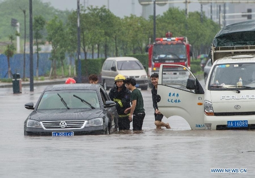  Firefighters help move a car trapped on a waterlogged road in southwest China's Chongqing Municipality, June 9, 2013. Heavy rainfall hit Chongqing as the city issued a red rainstorm warning here on Sunday. (Xinhua/Chen Cheng) 