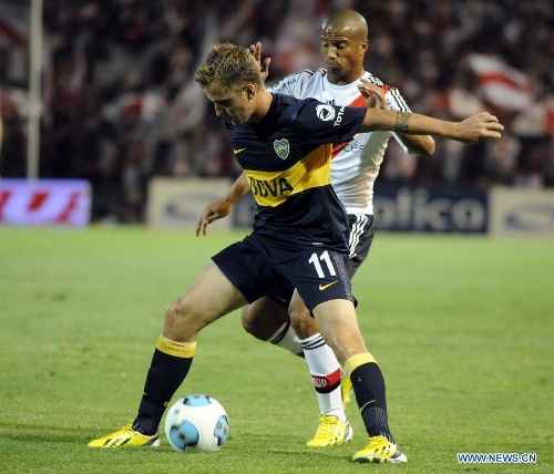Nicolas Colazo (front) of Boca Juniors vies for the ball with Carlos Sanchez of River Plate during the second match of the 