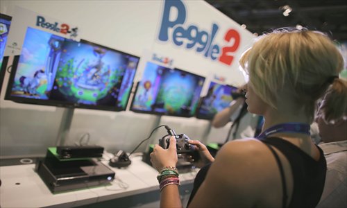 A woman tests the new Xbox One Wednesday at a Microsoft booth at the Gamescom trade fair for video games in Cologne, Germany. Gamescom takes place until Sunday in Germany's fourth-largest city. Photo: IC
