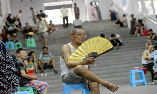 An elderly resident in Chongqing fans himself in an air raid shelter in the city on Tuesday, after the city's meteorological authorities posted an orange alert for high temperatures for three days in a row, and its temperature hit 40 C. The municipality has opened 111 shelters for residents who are seeking a cool place. The shelters do not have air conditioning. Photo: CFP