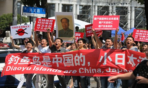 Chinese residents protest against the Japanese government near the Japanese Consulate on Xingyi Road in Changning district Sunday. Photo: Global Times