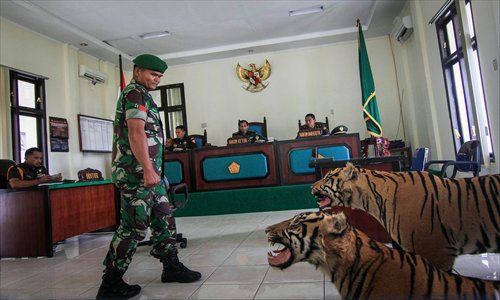 In this picture taken on Thursday, an Indonesian army officer enters the court room to listen to the judge's sentence in Banda Aceh, northern Sumatra island. An Indonesian military tribunal has jailed two soldiers for illegally possessing two stuffed Sumatran tigers and a stuffed bear, with the men forced to appear in court alongside the protected animals. Photo: AFP