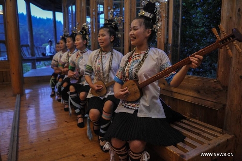 People play the Chinese lute in Dimen Dong minority village in Liping County of southwest China's Guizhou Province, June 20, 2013. Dimen is a Dong minority village with about 2,500 villagers. It is protected properly and all the villagers could enjoy their peaceful and quiet rural life as they did in the past over 700 years. (Xinhua/Ou Dongqu)
