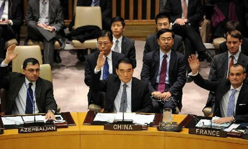 Li Baodong (C), the Chinese permanent representative to the United Nations, votes during a Security Council meeting at the UN headquarters in New York, the United States, January 22, 2013. The UN Security Council on January 22 condemned the satellite launch on December 12 by North Korea. Photo: Xinhua