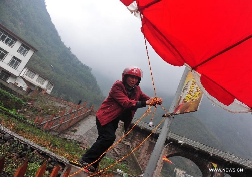Villager Wang Angui, 43, installs the lighting equipment in quake-hit Yuxi Village of Lushan County, southwest China's Sichuan Province, April 23, 2013. A 7.0-magnitude jolted Lushan County on April 20. (Xinhua/Xiao Yijiu) 