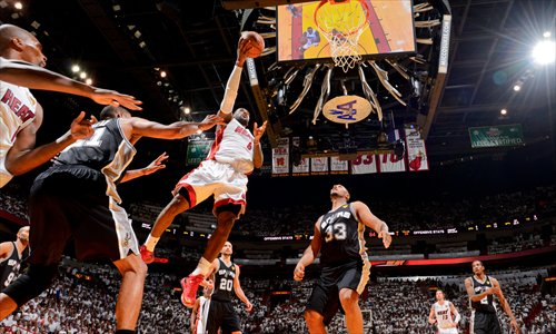 LeBron James (No.6) of the Miami Heat drives to the basket against Boris Diaw (No.33) of the San Antonio Spurs on Tuesday. Photo: AFP