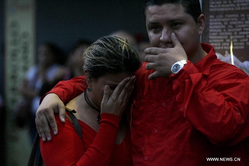 Residents mourn after they heard the announcement of Venezuelan President Hugo Chavez's death, in Caracas, Venezuela, on March 5, 2013. Venezuelan President Hugo Chavez died on March 5, Vice President Nicolas Maduro has announced. (Xinhua/Juan Carlos Hernandez) 