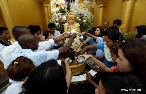 People offer water on the first day of Myanmar new calendar year at the world-famous Shwedagon Pagoda in Yangon, Myanmar, April 17, 2013. On Myanmar new year's day, people in the country used to perform meritorious deeds and Buddhists, who account for the majority of the people, usually go to the pagodas, monasteries and meditation centers where they practice meditation. (Xinhua/U Aung)