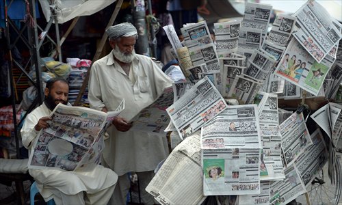 Pakistani men read the newspapers in Rawalpindi on Sunday, a day after the general elections. Former Pakistani leader Nawaz Sharif appealed for cross-party support to help rebuild the nuclear-armed but economically crippled nation after winning historic elections that defied Taliban violence. Photo: AFP