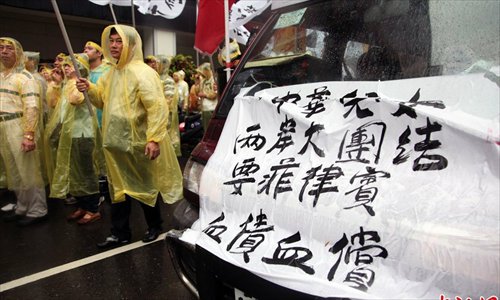 Members of a non-governmental group China Patriotic Association protest alongside fishermen from Pingdong, Taiwan outside the Manila Economic and Cultural Office in Taipei on May 13. The pictured banner reads “Chinese mainland and Taiwan should join to urge the Philippines to apologize for the death of the fisherman and offer compensation.” Photo: China News Service