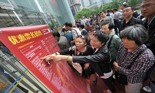 Residents check a list of discounted ticket prices Wednesday for the 15th China Shanghai International Arts Festival. Nearly 18,000 discounted tickets were sold for 47 performances between October 18 and November 18. The average ticket price was 50 yuan ($8). Photo: Cai Xianmin/GT