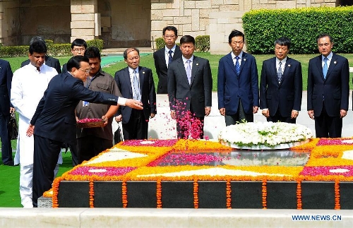 Chinese Premier Li Keqiang (L) scatters petals to the memorial of Mahatma Gandhi after laying a wreath, in New Delhi, India, May 20, 2013. (Xinhua/Li Tao) &nbsp;