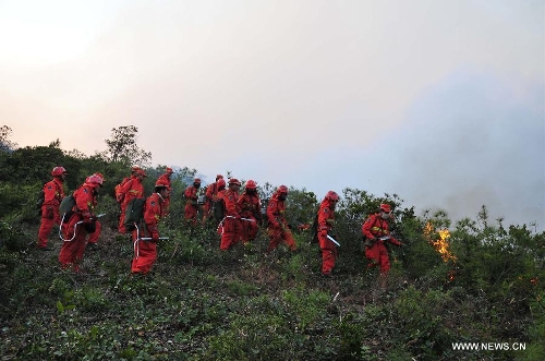 Forest policemen try to put out a forest fire in Anning, southwest China's Yunnan Province, April 9, 2013. The fire broke out around 1 p.m. (0500 GMT) in Anning City. Forest policemen and firefighters have been mobilized to quench the fire. (Xinhua/Zhong Yaojun) 