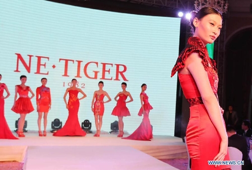 A model presents a creation during a fashion show of NE·TIGER's high-end formal gowns in Qingdao, east China's Shandong Province, April 19, 2013. (Xinhua/Li Ziheng) 