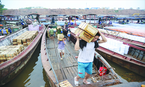 Workers carry goods imported from Vietnam Monday in Dongxing, South China's Guangxi Zhuang Autonomous Region. The total trade volume between Guangxi and member states of the Association of Southeast Asian Nations reached $1.59 billion in the first two months of this year, up 20.8 percent year-on-year. Photo: CFP 