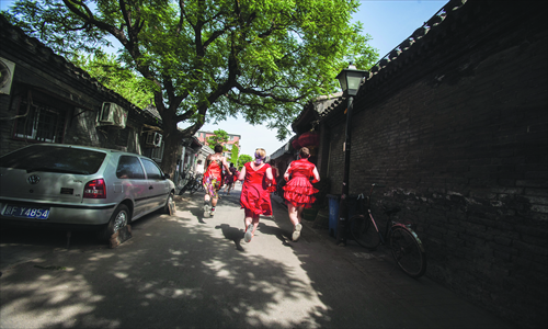 The hutong filled with flowing red dresses paired with beat-up running kicks. Photo: CFP
