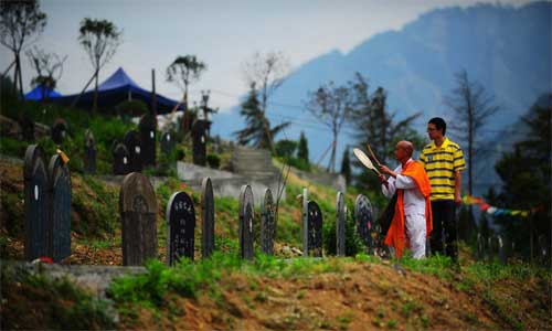 75-year-old Iwata visits the mass graves in Yingxiu, Wenchuan county, Sichuan Province to pray for the victims of the Wenchuan earthquake in 2008. He beat the drum with Buddhist scriptures, wearing two cloth bags with the word Apology written over his shoulders.