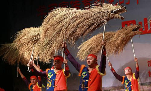 Farmers from Jinshan district perform a customary grass dragon folk dance at the Shanghai Vocational College of Agriculture and Forestry Thursday. Photo: Xinhua