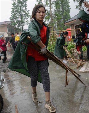 Liao Zhi, who lost her legs in the 2008 Wenchuan earthquake and wears prosthetic legs, helps with relief efforts in Lushan, Sichuan Province three days after a 7.0 quake occured on April 20. Photo: CFP