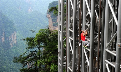 French climber Jean-Michel Casanova made it to the top of Hunan Province's 172-meter Bailong Elevator, the tallest outdoor structure of its kind in the world, in 68 minutes and 26 seconds on Saturday. Photo: CFP