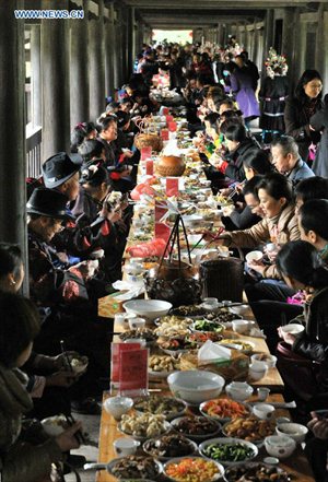 People of the Dong ethnic group walk through the Chengyang Fengyu Bridge in Sanjiang Dong Autonomous county, Southwest China's Guangxi Zhuang Autonomous Region, December 1, 2012. A celebration ceremony was held on Saturday to mark the 100th anniversary of the completion of Chengyang Fengshui Bridge. Built in 1912, the 77.76-meter-long bridge is famed for its combination of bridge, veranda and Chinese pavilion. (Xinhua/Wu Lianxun) 



