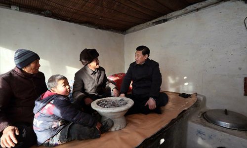 Xi Jinping (R), general secretary of the Communist Party of China (CPC) Central Committee and chairman of the CPC Central Military Commission, visits the family of Tang Rongbin, an impoverished villager in the Luotuowan Village of Longquanguan Township, Fuping County, north China's Hebei Province. Xi made a tour to impoverished villages in Fuping County from Dec. 29 to 30, 2012. Photo: Xinhua