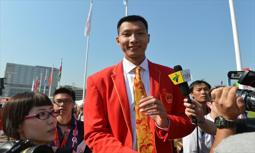 Basketball star Yi Jianlian talks to media at the flag-raising ceremony in the Games Village in east London on Wednesday. Yi is expected to be China's flag bearer at the opening ceremony of the London Olympic Games on Friday. Photo: AFP 