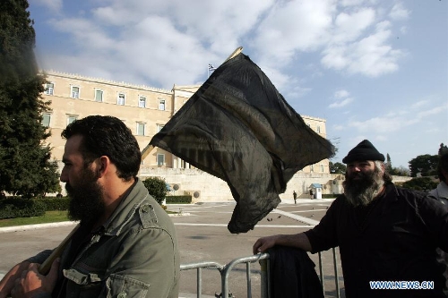 Greek farmers shout slogans and hold banners in central Athens of Greece, on March 5, 2013. Thousands of farmers from across Greece gathered in central Athens on Tuesday to rally in front of the parliament in protest of harsh austerity policies which have altered dramatically their everyday life over the past three years. (Xinhua/Marios Lolos) 