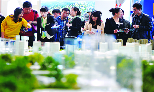 Potential home buyers look at model buildings at the Beijing Spring Real Estate Trade Fair Saturday. The fair attracted 210 overseas property companies from 25 countries and regions, many of which advertised investment in real estate as a potential path to immigration. Photo: CFP 