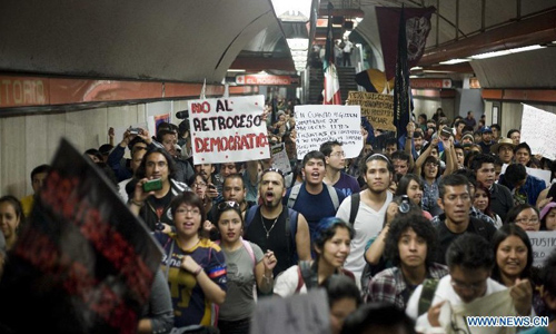 Residents walk into a subway station during a demonstration protesting against the outcome of the July 1 general elections, in Mexico City, capital of Mexico, on July 22, 2012. Protesters marched to the Zocalo in downtown Mexico City. Thousands of demonstrators marched through Mexico City on Sunday to protest the outcome of the July 1 general elections, which declared Institutional Revolutionary Party (PRI) presidential candidate Enrique Pena Nieto the winner. Photo: Xinhua