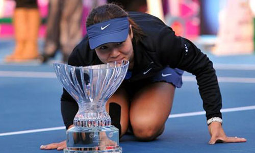 Li Na crouches and kisses the trophy after beating the fifth seed, Klara Zakopalova, from Czech 6-3 1-6 7-5 in the final of the Shenzhen Open on Saturday, January 4, 2013. Photo: icpress.cn