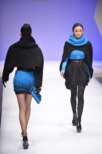 Models present creations in the WSM China Knitwear Fashion Design Contest 2013 during the China Fashion Week in Beijing, capital of China, March 26, 2013. The design by Sheng Lina from Fashion School & Engineering of Zhejiang Sci-Tech University won the championship of the contest. (Xinhua/Li Xin)  