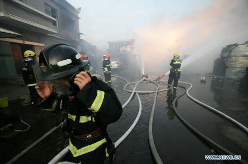 Firefighters hose down fire at a workshop in Zhenhai District of Ningbo, East China's Zhejiang Province, August 1, 2012. The fire broke out in a renewable resources plant in Ningbo at about 5 pm Wednesday, leave one person dead and 18 others injured. The investigation of the reason of the fire is underway. Photo: Xinhua
