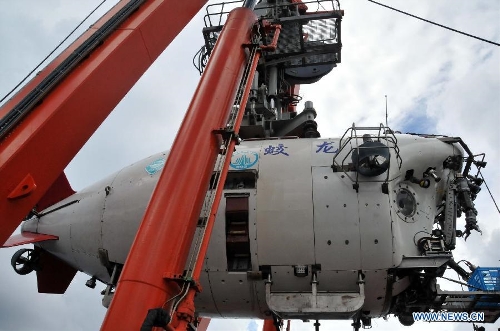 China's manned submersible Jiaolong is hoisted by its support ship Xiangyanghong 09 in the South China Sea, July 5, 2013. The Jiaolong manned submersible on Friday carried out a scientific dive to collect rock samples from the Jiaolong Seamount in the South China Sea. (Xinhua/Zhang Xudong) 