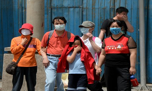 People wear masks to protect against air pollution and dust in Beijing on Sunday.  China will more than double the number of cities covered by air quality monitoring, as part of efforts to tackle heavy smog that has sparked huge public anger. Photo: AFP