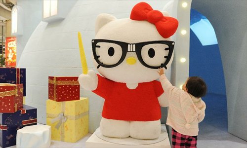 A little girl plays around a red Hello Kitty in the Joy City in east China's Shanghai Municipality, Nov. 26, 2012. A big Hello Kitty exhibition themed on Hello Kitty's exploration in the polar regions would last from Nov. 24, 2012 to Feb. 24, 2013 in Shanghai. Photo: Xinhua