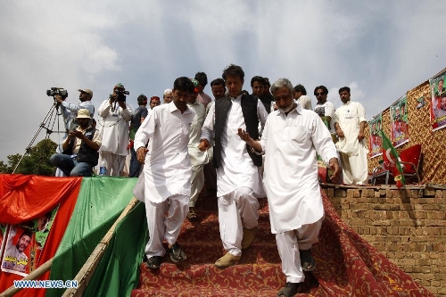 Pakistan's former cricket star-turned-politician Imran Khan (C) leaves during an election campaign rally in Charsadda, Pakistan, on May 4, 2013. Pakistan is scheduled to hold parliamentary elections on May 11. (Xinhua/Umar Qayyum)&nbsp;