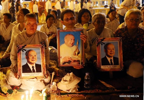 People sit to pay their respects to the late former king Norodom Sihanouk in front of the Royal Palace in Phnom Penh, capital of Cambodia, on Feb. 3, 2013. The royal cremation ceremony of the late former Cambodian King Norodom Sihanouk will be held on Monday. (Xinhua/Yao Dawei) 
