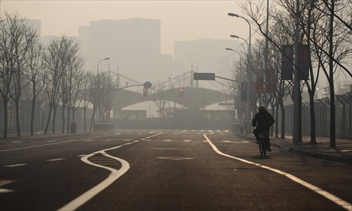 A bicyclist rides through the heavy smog in Huangpu district Wednesday, when the city's air pollution index hit a record high. Photo: Cai Xianmin/GT