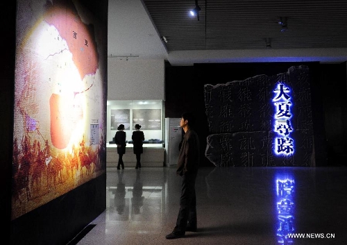 Visitors appreciate cultural relics of the Kingdom of Xia on display in an exhibition in Changchun, capital of northeast China's Jilin Province, May 15, 2013. An exhibition of the cultural relics of the Kingdom of Xia, a regime founded in west China in 1038, was held here on Wednesday, in which more than 100 cultural relics of the kingdom excavated since the founding of the People's Republic of China in 1949 were shown to the public. (Xinhua/Xu Chang)  