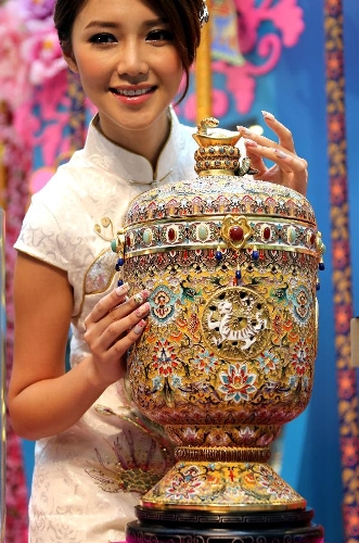 A piece of cloisonne work made by artist Zhang Tonglu is presented by Elva Ni, the winner of 2005 Miss Chinese Toronto Pageant, during an exhibition in south China's Hong Kong, Jan. 22, 2013. An exhibition of Zhang Tonglu's cloisonne art works was held here on Tuesday, showing 22 pieces of cloisonne works. (Xinhua/Li Peng) 