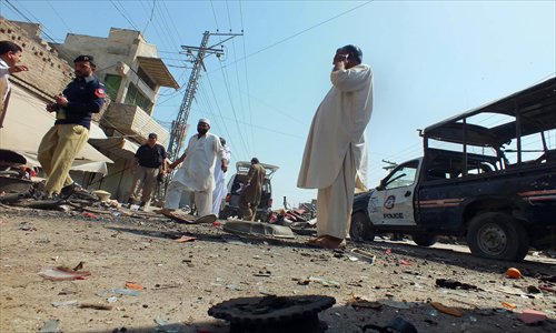 Pakistani security officials examine the site of a bomb explosion in the town of Bannu, in Khyber Pakhtunkhwa Province on Tuesday. The remote-controlled bomb which was aimed at police killed two people, police said, hours after a blast near the home of a prominent provincial minister. Photo: AFP