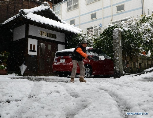 A boy shovels the pavement in Tokyo, capital of Japan, Jan. 14, 2013. A storm system hit eastern Japan on Monday resulting in heavy snow fall that had impacted on traffic in many prefectures, including the capital city of Tokyo. (Xinhua/Ma Ping) 