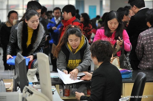 Citizens conduct housing transactions at the Housing Transaction Center in Shijiazhuang, north China's Hebei Province, March 8, 2013. Secondhand housing transaction surges in the city these days as buyers and sellers are rushing to 