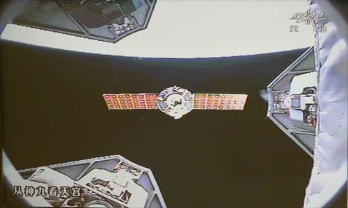Shenzhou-9 spacecraft parts with the Tiangong-1 lab module. A manual docking between the Shenzhou-9 and Tiangong-1 was successfully conducted yesterday, following an automated docking on June 18. The astronauts are expected to return to Earth on Friday. Photo: Xinhua