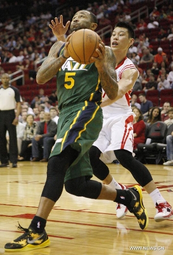 Houston Rockets' Jeremy Lin (R) tries to block a shot during the NBA basketball game against Utah Jazz, March 20, 2013, in Houston. Rockets beat Jazz 100-93.(Xinhua/Song Qiong)&nbsp; 