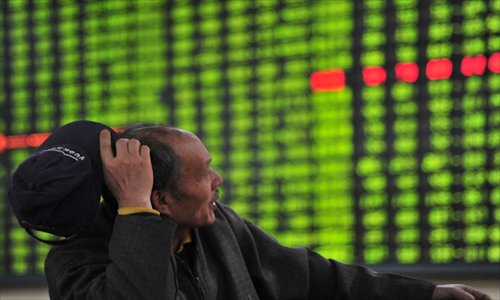 An investor watches a stock price screen Monday at a securities company in Jiujiang, Jiangxi Province. The Shanghai Composite Index plunged 3.65 percent Monday, the biggest drop since August 2011. Photo: CFP